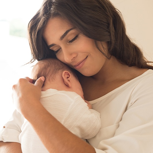 Mother holding baby after lip and tongue tie treatment