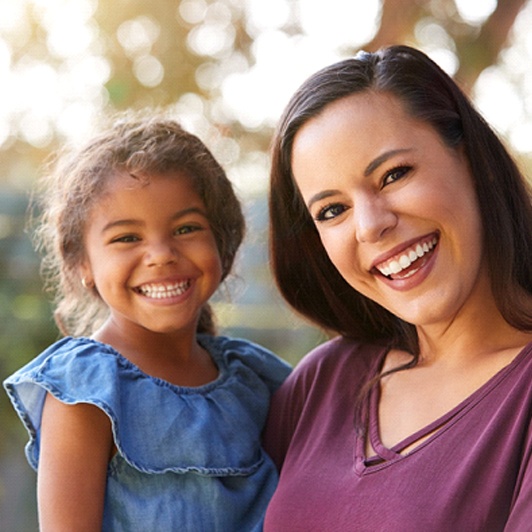 A mother holding her daughter who is speaking better because of a frenectomy in Phillipsburg