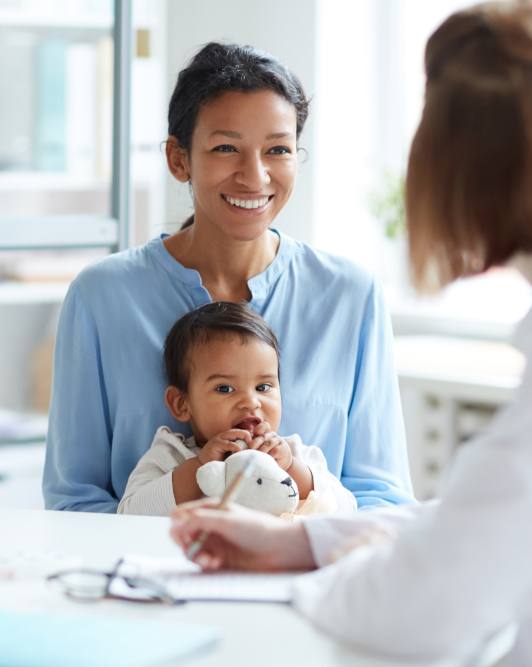 Mother and infant talking to dental team member