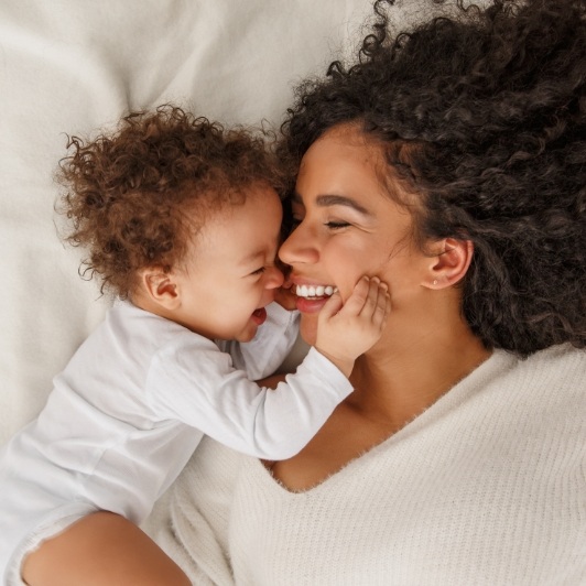 Mother smiling at laughing infant