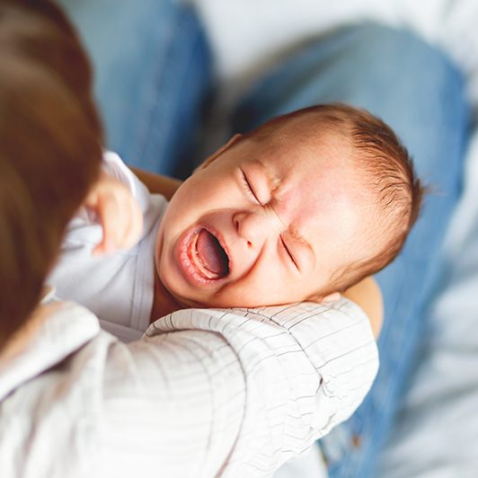 Crying baby in need of lip and tongue tie treatment