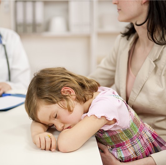 Child with head on arms in dental office