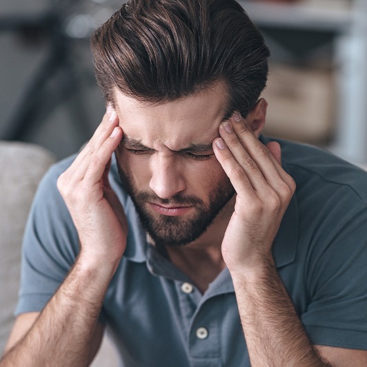 Man with headache in need of lip  and tongue tie treatment