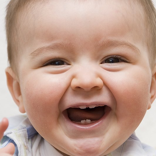 Baby with lip and tongue-tie laughing