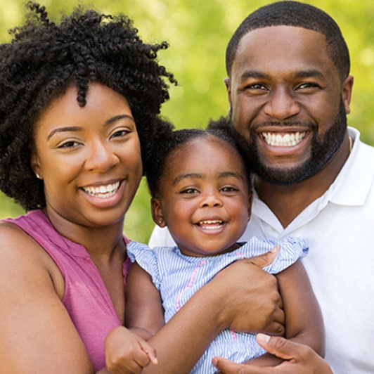 A mother and father holding their baby and smiling in Phillipsburg