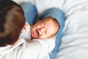 crying baby with colic and a tongue tie