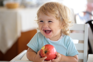 a small infant eating an apple