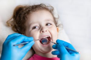 a child having their mouth examined by a lip and tongue tie specialist