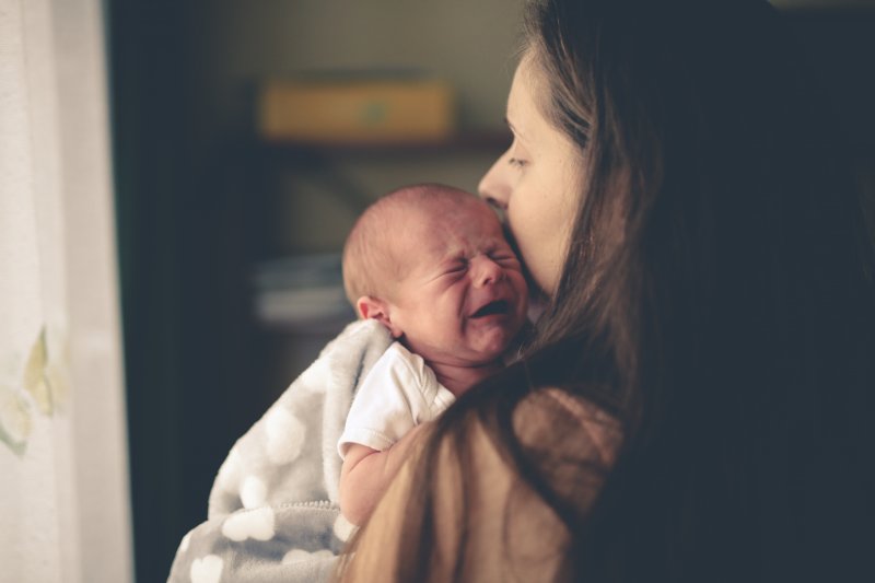 Baby cries in mother's arms